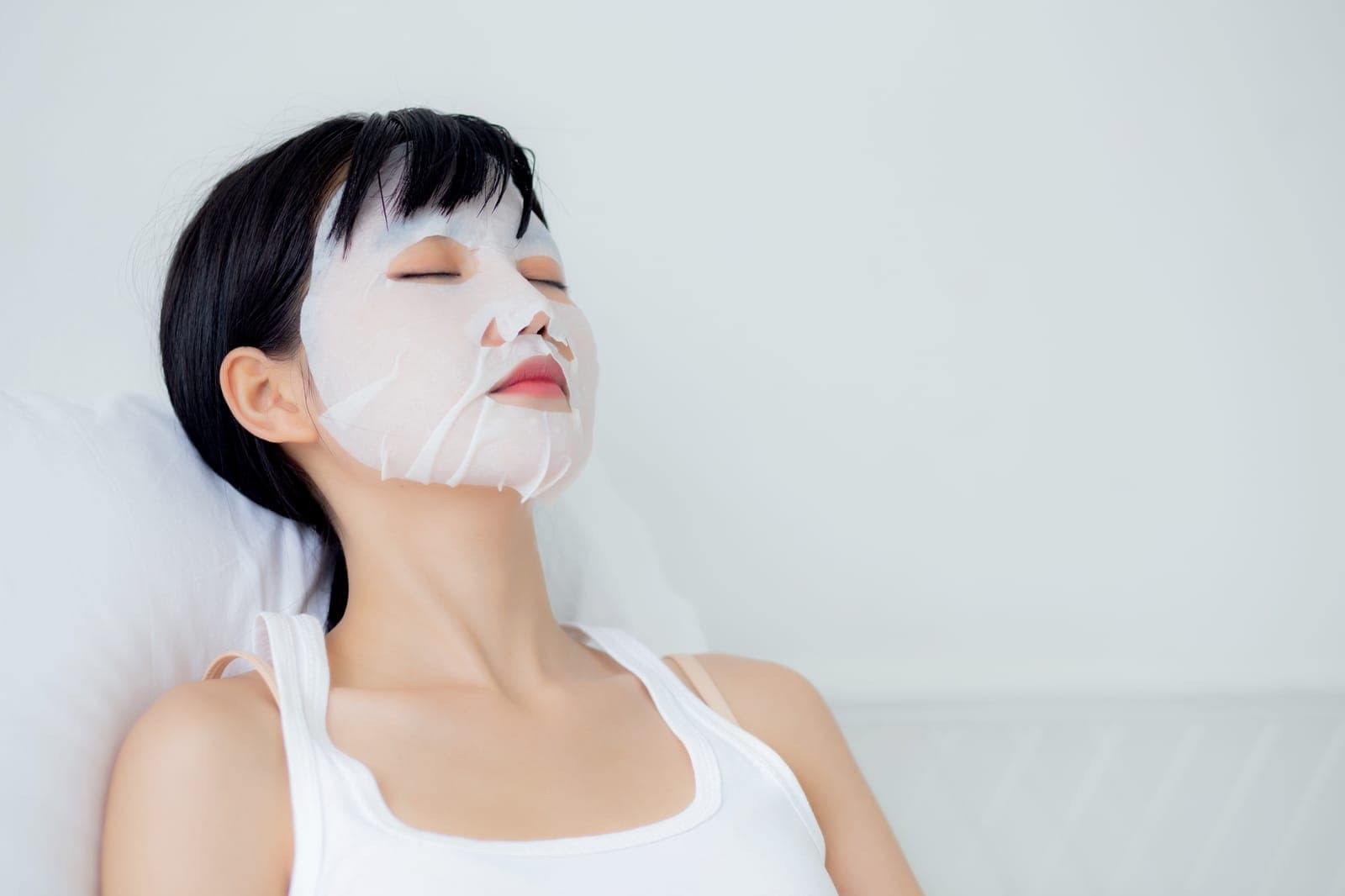 敷膜瞬間 — 亞洲女性閉眼安祥、白色背景儀式氛圍